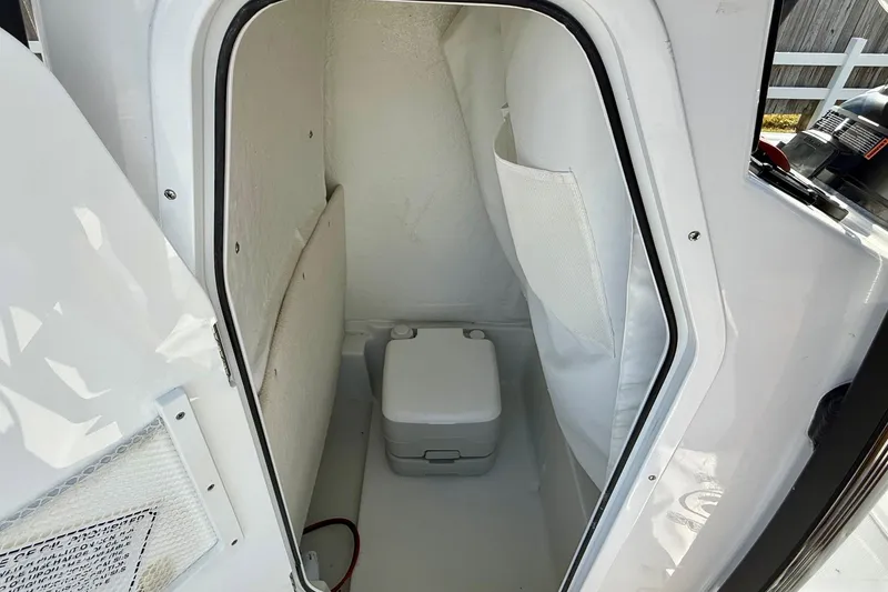Slide: The Image of 2026 Sea Hunt BX 22 BR boat interior with compact toilet and storage area. - 14