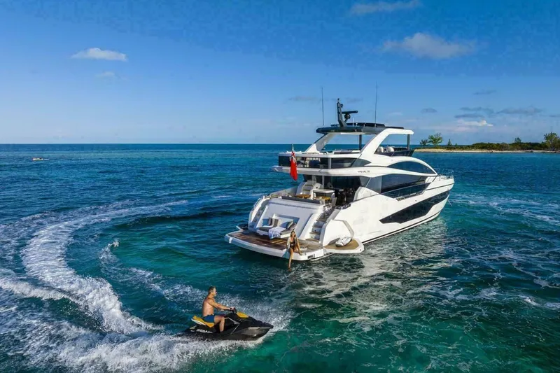 Slide: The Image of Luxurious 2025 Pearl 72 yacht on clear blue ocean with jet ski nearby. - 48