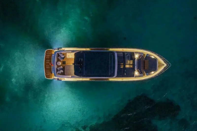 Slide: The Image of Aerial view of illuminated 2025 Pearl 72 yacht on serene water at night. - 49