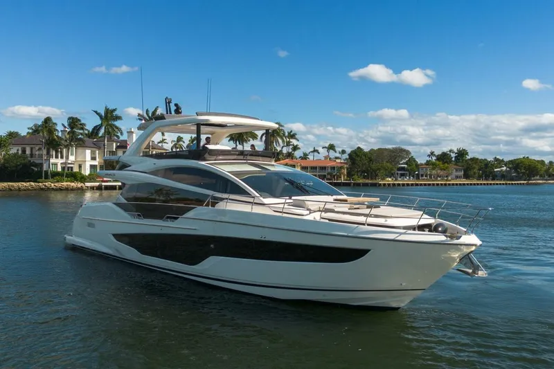 Slide: The Image of Luxurious 2025 Pearl 72 yacht cruising on a sunny day near waterfront homes. - 53