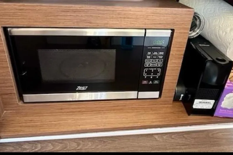 Slide: The Image of Microwave and coffee machine in 2024 Beneteau Antares 9 kitchen area. - 12