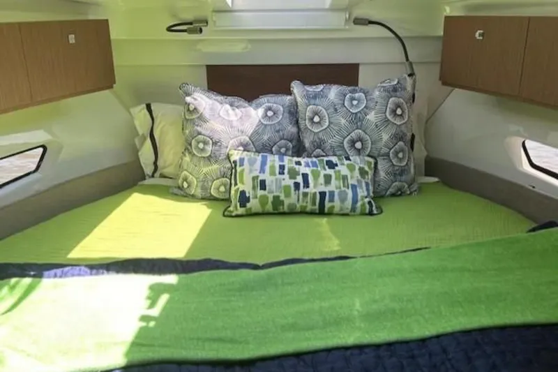 Slide: The Image of Cozy cabin interior of 2024 Beneteau Antares 9 with vibrant bedding and decorative pillows. - 15