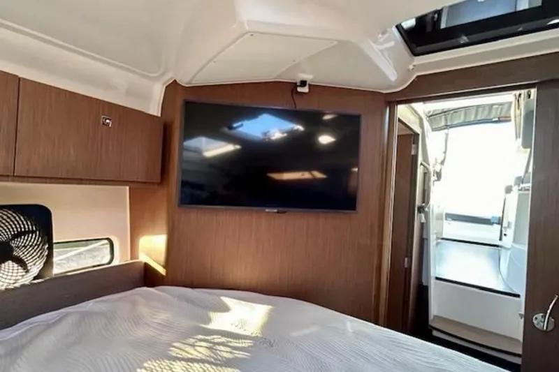 Slide: The Image of 2024 Beneteau Antares 9 cabin interior with TV and wooden finish. - 16