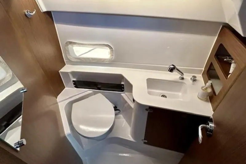 Slide: The Image of 2024 Beneteau Antares 9 bathroom interior with sink, toilet, and wooden accents. - 17