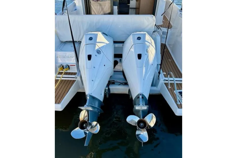 Slide: The Image of 2024 Beneteau Antares 9 with dual outboard engines, docked on calm water. - 2