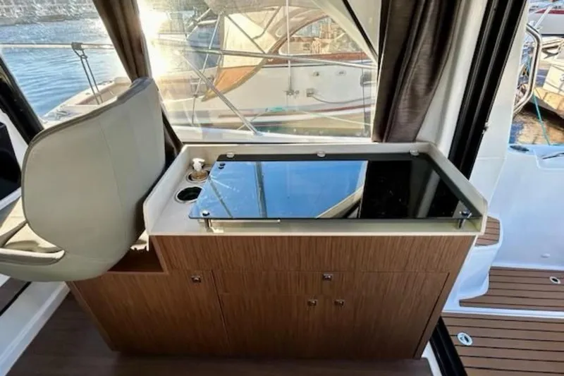 Slide: The Image of Interior of 2024 Beneteau Antares 9, featuring a sleek kitchenette with a glass cooktop. - 7