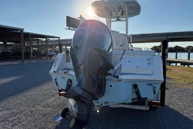 Slide: The Image of 2024 Tidewater 232 LXF boat with outboard motor, docked near a bridge at sunset. - 5