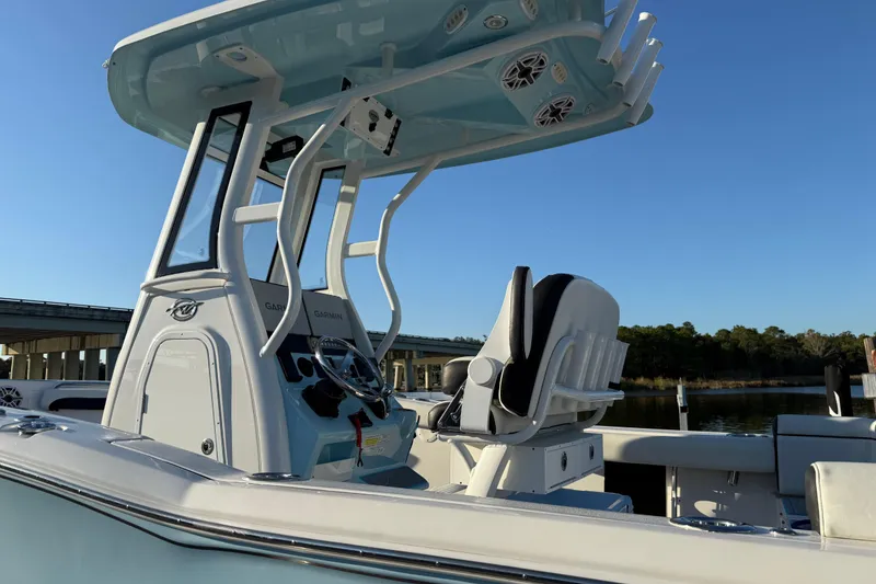 Slide: The Image of 2024 Tidewater 232 LXF boat with modern helm and seating, under clear blue sky. - 9
