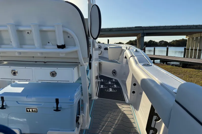 Slide: The Image of 2024 Tidewater 232 LXF boat interior with YETI cooler, near a bridge and waterway. - 11