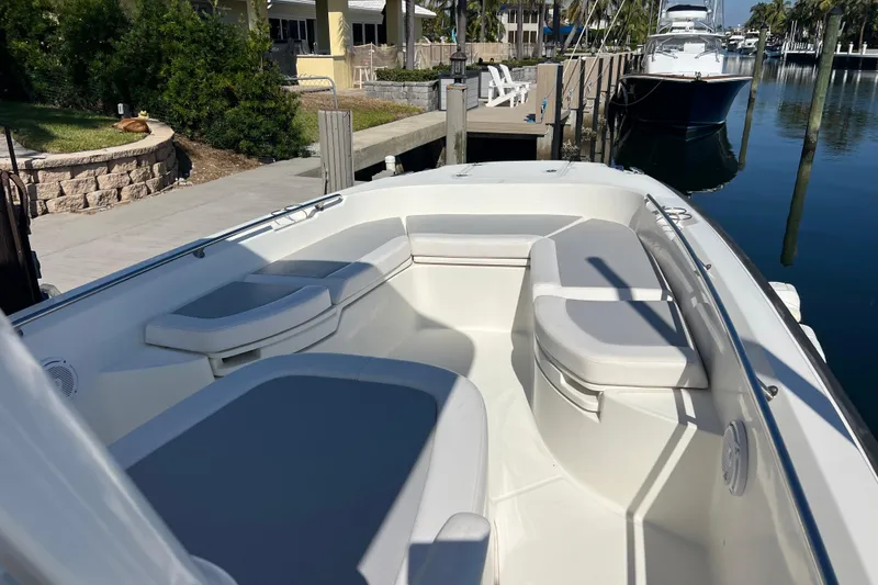 Slide: The Image of 2015 Boston Whaler 270 Dauntless boat interior with cushioned seating at dock. - 12