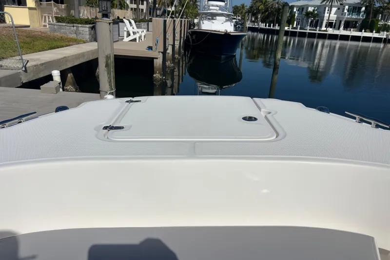 Slide: The Image of 2015 Boston Whaler 270 Dauntless docked in a serene marina setting. - 15