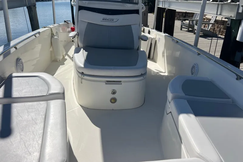 Slide: The Image of 2015 Boston Whaler 270 Dauntless boat interior with cushioned seating and helm. - 19