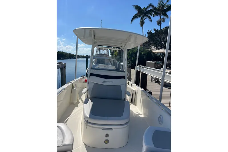 Slide: The Image of 2015 Boston Whaler 270 Dauntless boat docked by a scenic waterfront with palm trees. - 21