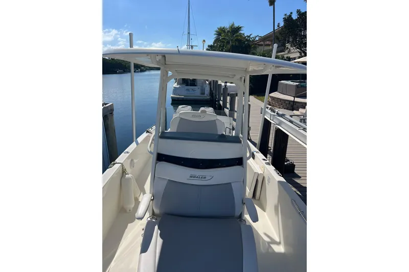 Slide: The Image of 2015 Boston Whaler 270 Dauntless boat docked by a serene waterfront. - 26