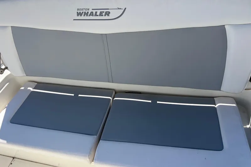 Slide: The Image of Boston Whaler 270 Dauntless 2015 boat seating with logo, featuring gray cushions. - 36