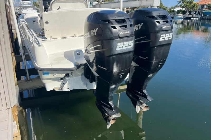 Slide: The Image of 2015 Boston Whaler 270 Dauntless with twin Mercury 225 Verado engines docked by water. - 51