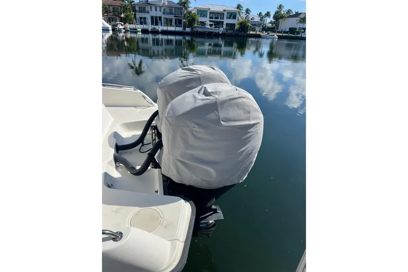 Slide: The Image of Boston Whaler 270 Dauntless 2015 with covered outboard motors on a calm waterfront. - 54