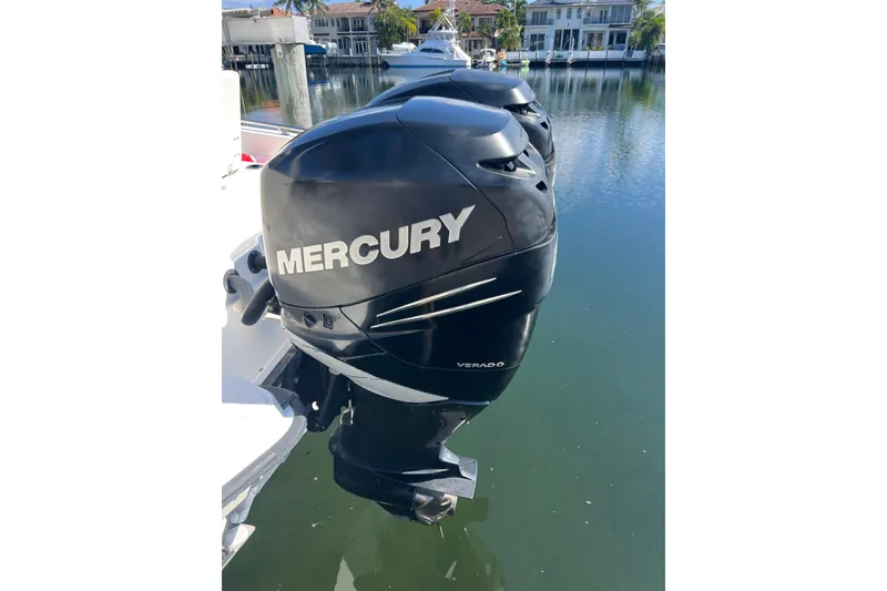Slide: The Image of Mercury Verado outboard engine on 2015 Boston Whaler 270 Dauntless, docked by waterfront homes. - 8