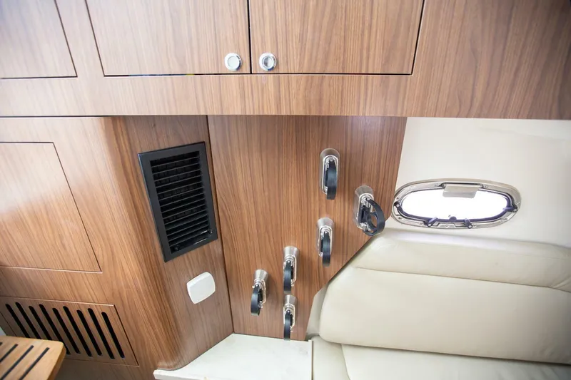 Slide: The Image of Interior of 2023 Boston Whaler 380 Outrage, featuring wood paneling and a small window. - 15