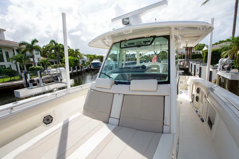 Slide: The Image of 2023 Boston Whaler 380 Outrage boat docked, showcasing spacious seating and sleek design. - 17