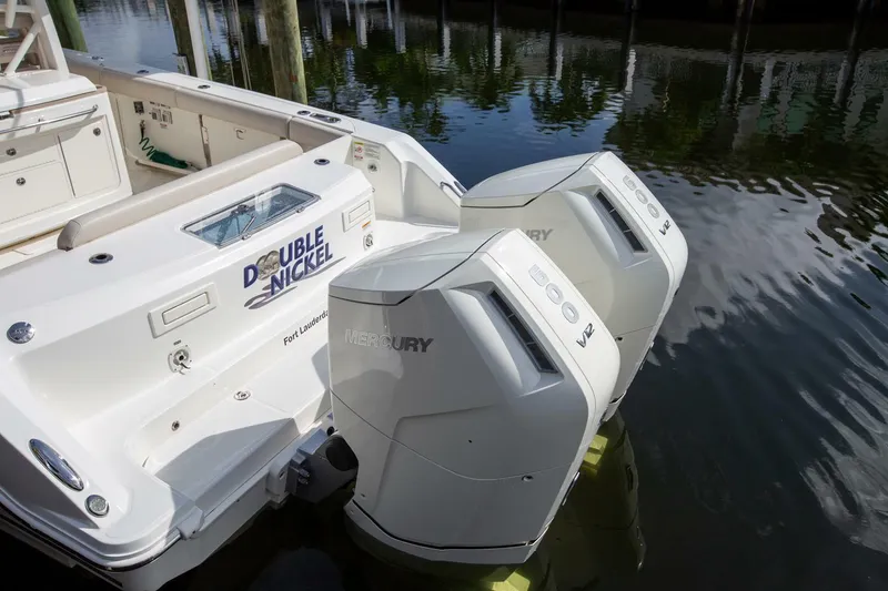 Slide: The Image of 2023 Boston Whaler 380 Outrage with dual Mercury V12 engines docked in water. - 19