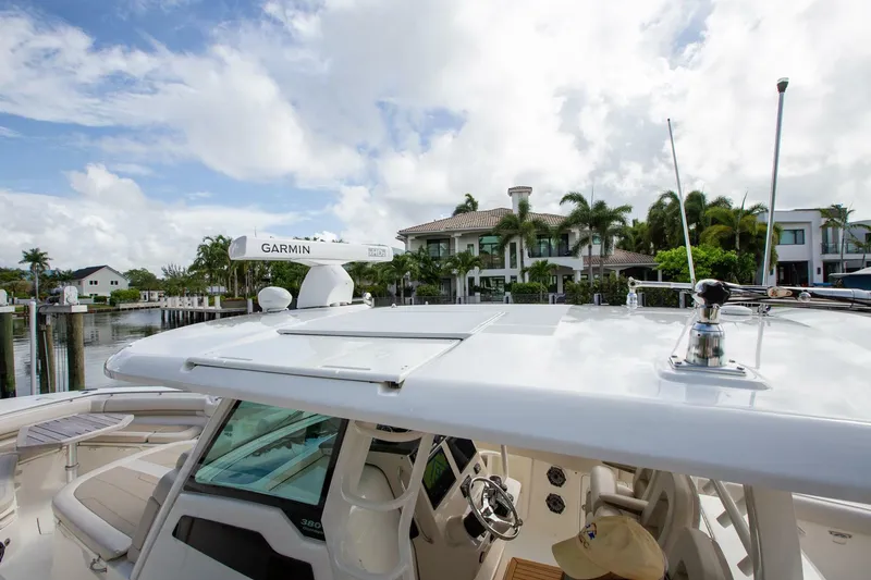 Slide: The Image of 2023 Boston Whaler 380 Outrage boat docked near waterfront homes, featuring Garmin equipment. - 20