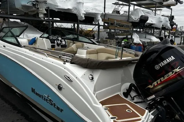 Slide: The Image of 2018 NauticStar 243DC Sport Deck boat with Yamaha engine, docked in marina. - 20