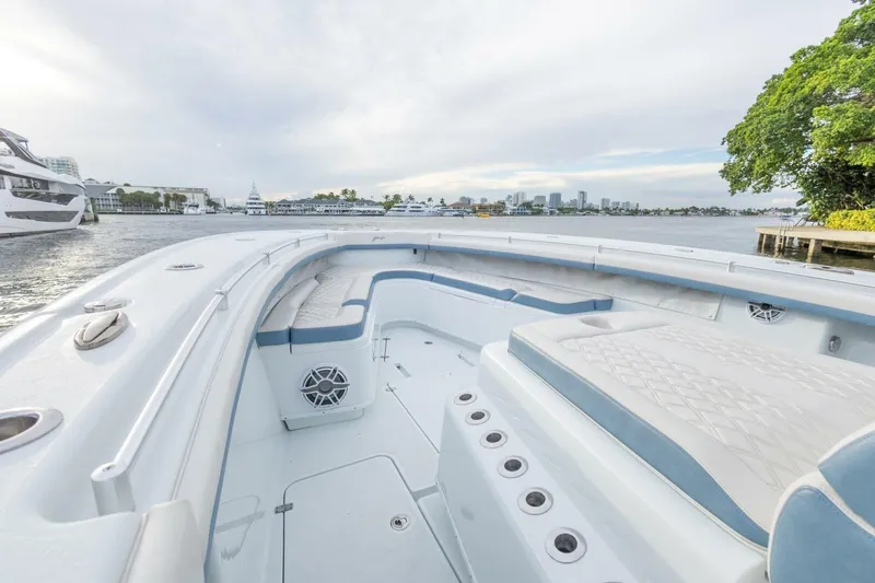 Slide: The Image of 2023 Yellowfin 42 Offshore boat interior with seating, on a calm waterfront. - 30