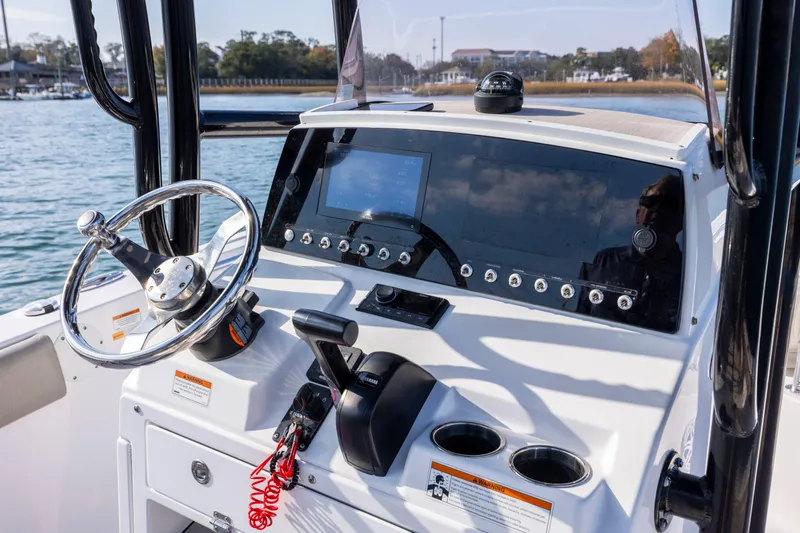 Slide: The Image of 2022 Sportsman Open 212 Center Console boat dashboard with steering wheel and controls. - 18