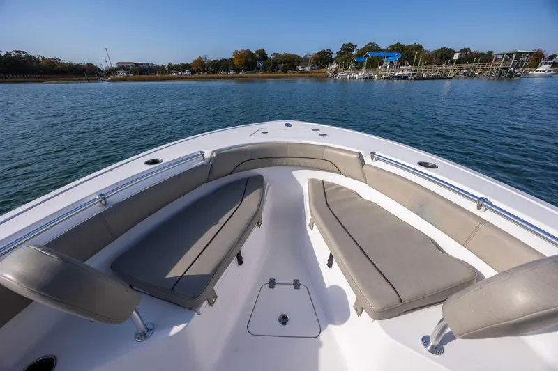 Slide: The Image of 2022 Sportsman Open 212 Center Console boat with cushioned seating on calm water. - 21