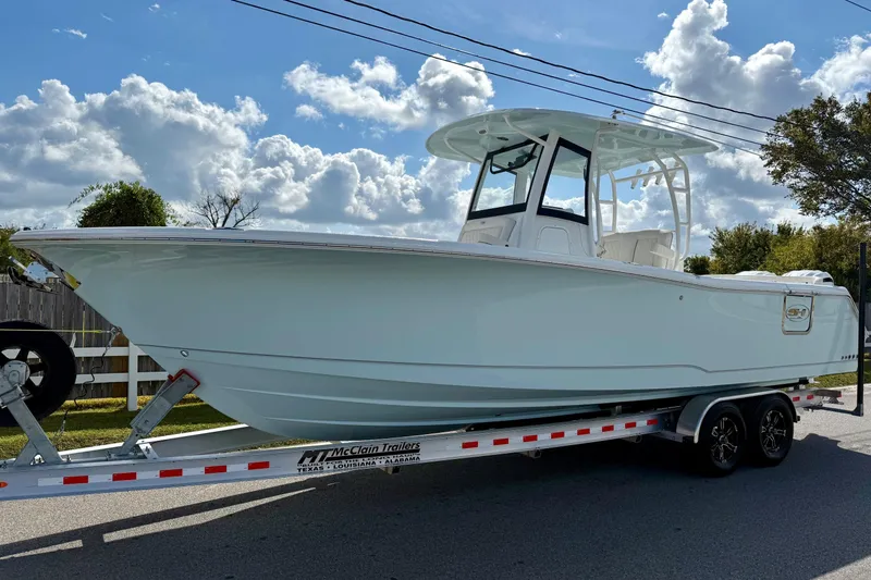 The Image of 2026 Sea Hunt Ultra 285 Coffin Box boat on trailer under cloudy sky. - 1