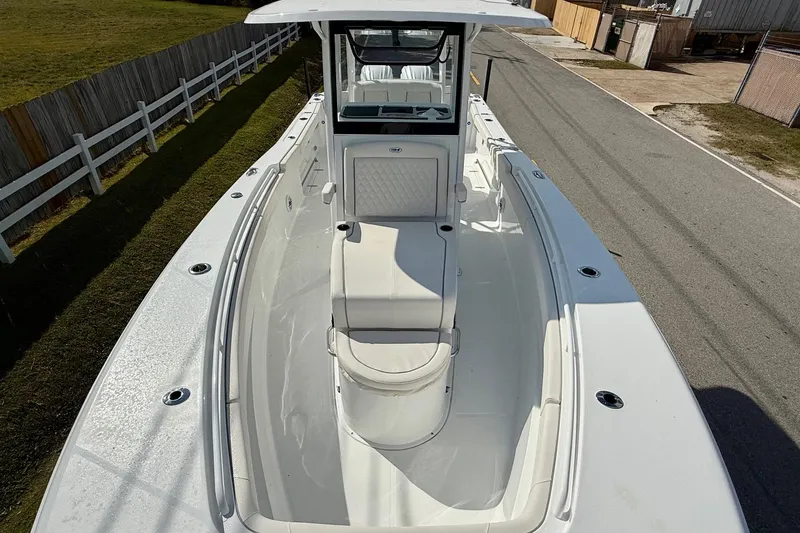 Slide: The Image of 2026 Sea Hunt Ultra 285 Coffin Box boat, white exterior, spacious deck, parked on a road. - 16