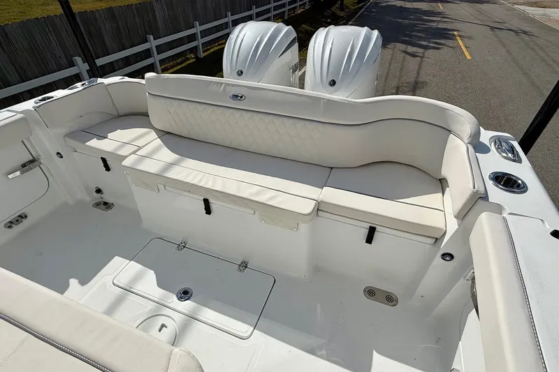 Slide: The Image of 2026 Sea Hunt Ultra 285 Coffin Box boat interior with white seating and dual engines. - 7