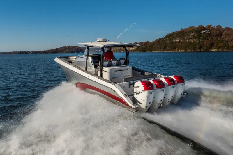 Slide: The Image of 2020 Fountain 43 NX boat speeding on a lake with four powerful engines. - 13