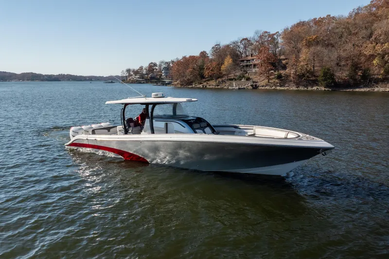 Slide: The Image of 2020 Fountain 43 NX boat cruising on a serene lake with autumn trees in the background. - 20
