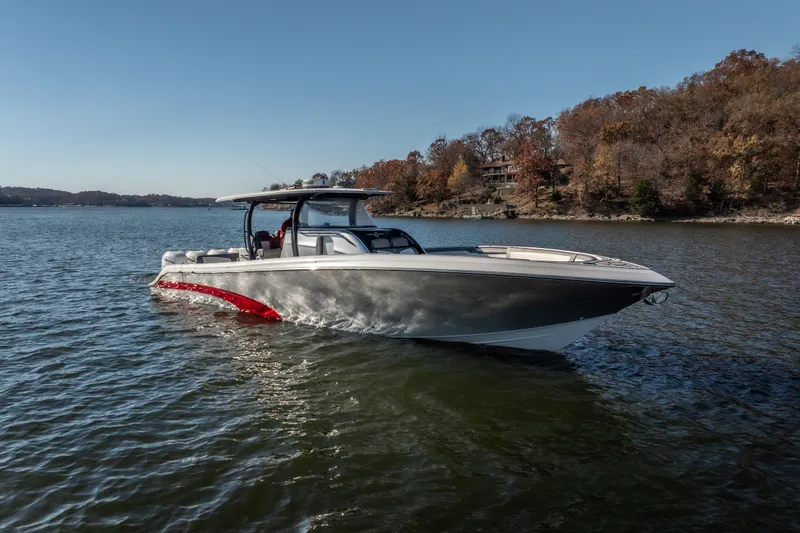 Slide: The Image of 2020 Fountain 43 NX boat cruising on a lake with autumn trees in the background. - 21