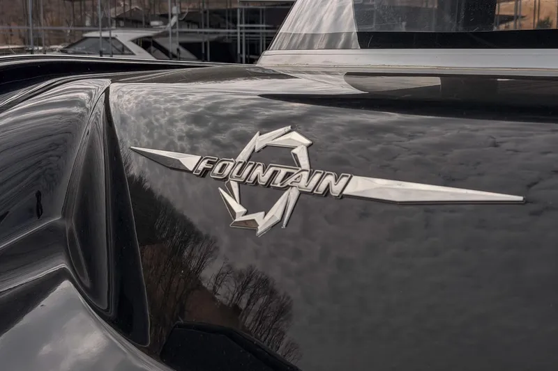 Slide: The Image of 2020 Fountain 43 NX boat logo on sleek black surface, reflecting cloudy sky. - 25