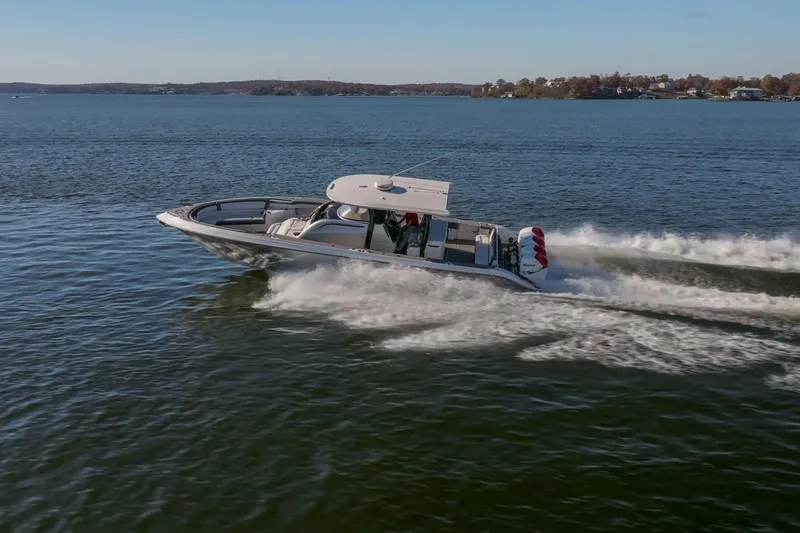 Slide: The Image of 2020 Fountain 43 NX boat cruising on a lake with scenic shoreline. - 3