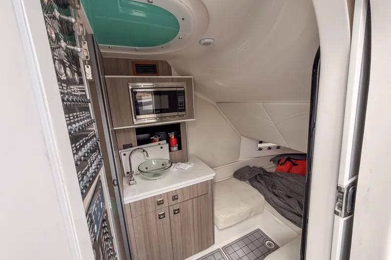 Slide: The Image of 2020 Fountain 43 NX cabin interior with kitchenette, sink, and sleeping area. - 33