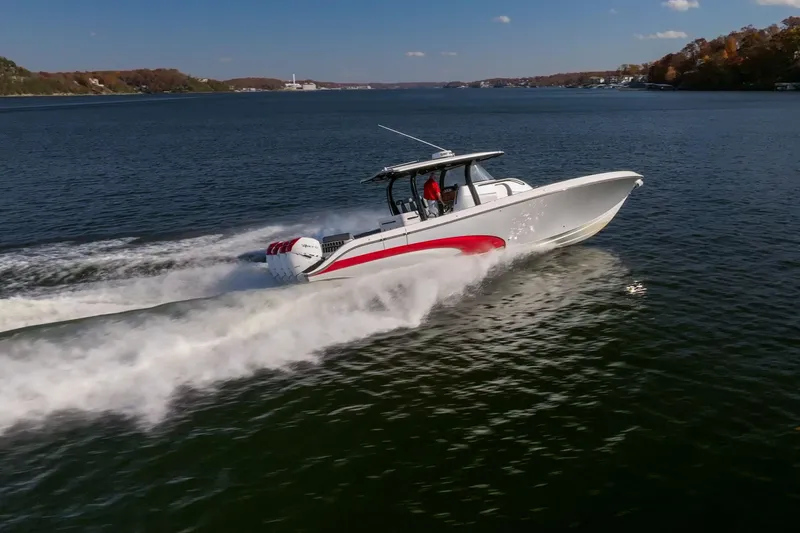 Slide: The Image of 2020 Fountain 43 NX speedboat cruising on a scenic lake under a clear blue sky. - 4