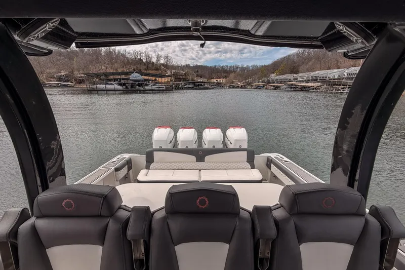 Slide: The Image of 2020 Fountain 43 NX boat interior with four engines, docked on a serene lake. - 42