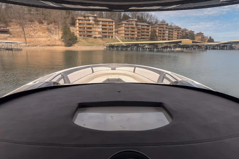 Slide: The Image of View from a 2020 Fountain 43 NX boat, overlooking a serene lake and waterfront buildings. - 52