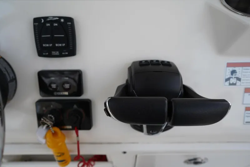 Slide: The Image of Control panel of 2022 Cobia 266 boat with throttle and switches. - 10