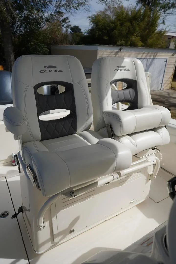 Slide: The Image of 2022 Cobia 266 boat seats, white leather, outdoor setting. - 12