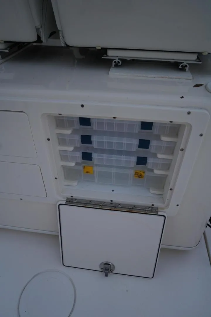 Slide: The Image of 2022 Cobia 266 boat storage compartment with organized tackle boxes. - 14
