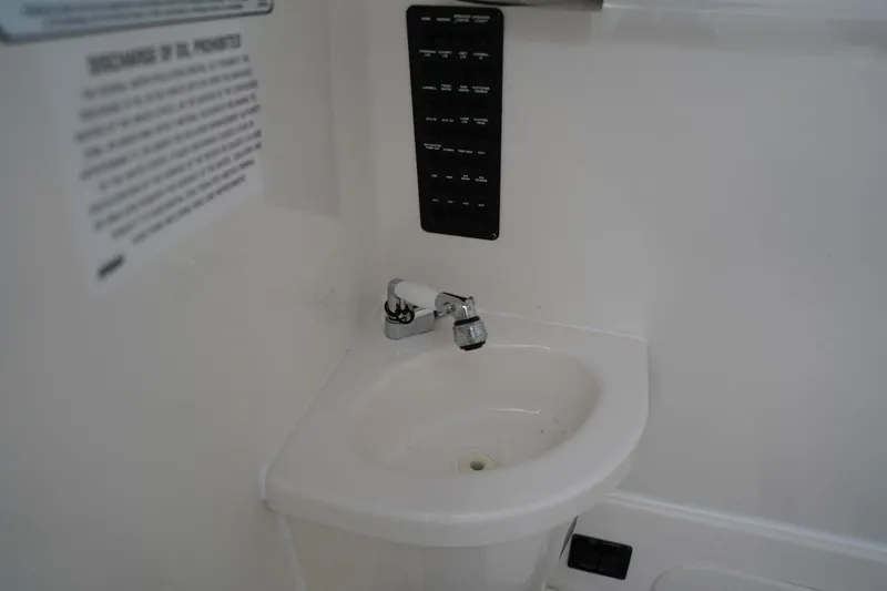 Slide: The Image of 2022 Cobia 266 boat interior sink with faucet and control panel. - 24