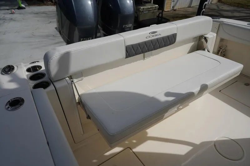Slide: The Image of 2022 Cobia 266 boat with cushioned seating and dual outboard motors. - 25