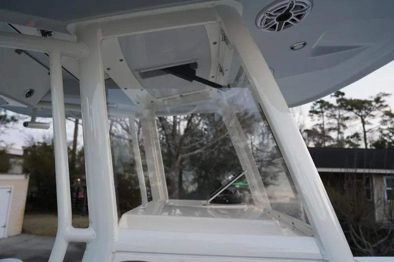 Slide: The Image of 2022 Cobia 266 boat helm with clear windshield and overhead speaker. - 4