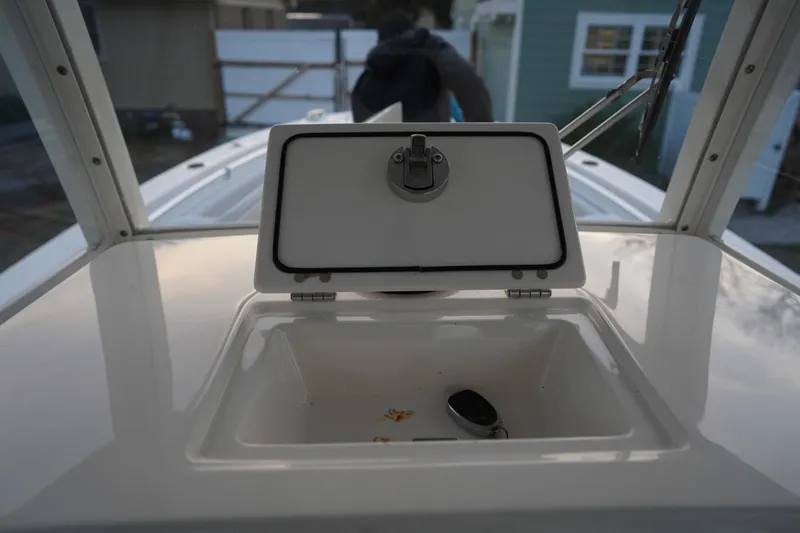 Slide: The Image of 2022 Cobia 266 boat storage compartment with open lid, showcasing interior space. - 40