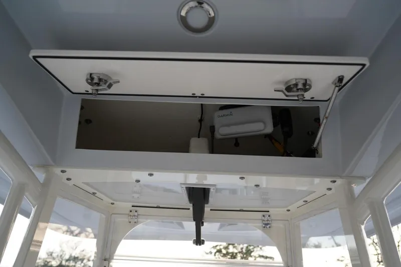 Slide: The Image of 2022 Cobia 266 boat storage compartment with open hatch, showcasing interior equipment. - 42